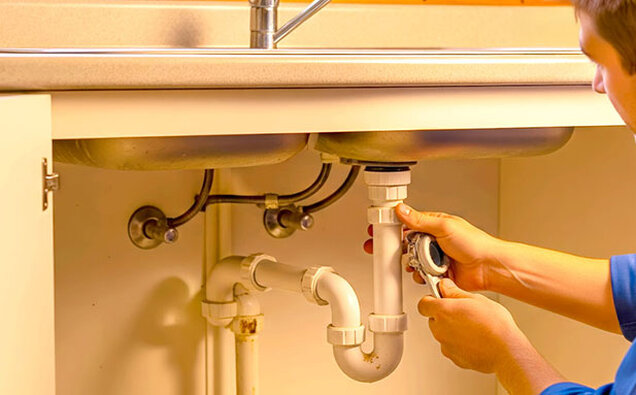 Plumber Tightening Sink Pipe